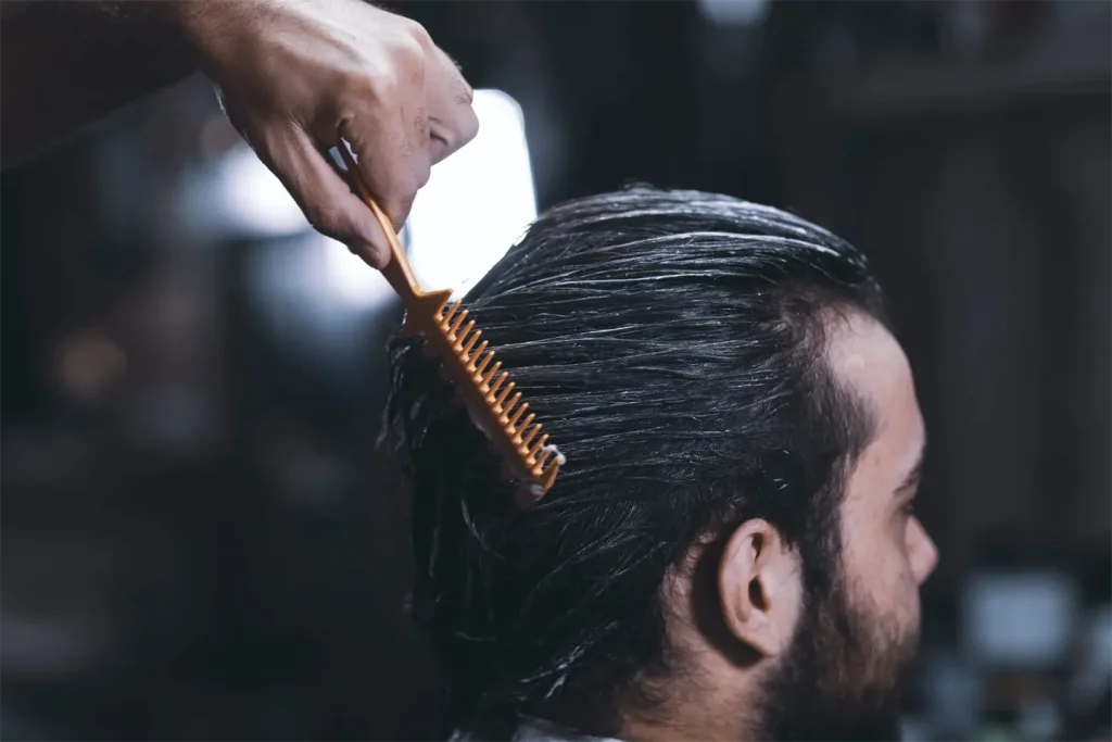 Close shot of a barber hand performing a haircut with a brush